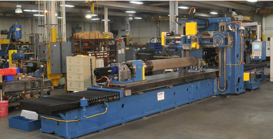 A worker operates a grinder cutting metal, creating a vibrant display of sparks in an industrial setting.